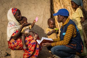 12 December 2016 - Mainé Soroa, Diffa region, Niger. Saibou Bassirou, Protection officer at SOS, takes information about Falmata and her son.  Falmata was reunited to her family thanks to the NGO.